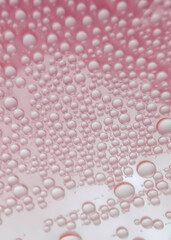 Naklejka na ściany i meble Water drops on pink background texture. backdrop glass covered with drops of water. bubbles in water