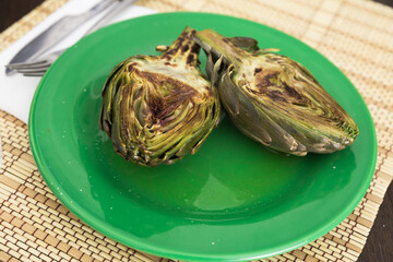 cooked fried halves artichokes on green plate
