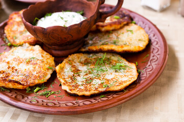 belarusian draniki with sour cream and herbs in a restaurant