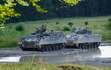 a British army Warrior FV510 light infantry fighting vehicle tank being towed by a Warrior FV512...
