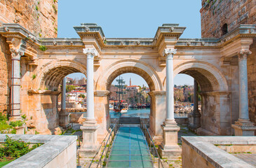 Naklejka premium View of Hadrian's Gate in old city of Antalya - Old town (Kaleici) in the background Konyaalti beach and mountains - Antalya, Turkey