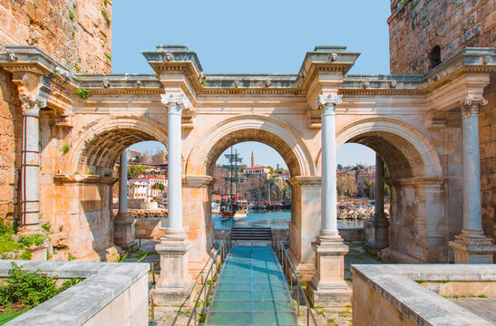 View of Hadrian's Gate in old city of Antalya - Old town (Kaleici) in the background Konyaalti beach and mountains - Antalya, Turkey