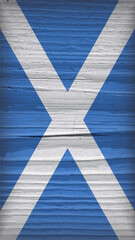 Flag of Scotland on a dry wooden surface. Vertical mobile phone wallpaper. Vintage background of old wood with vignetting. Rough board with cracks. The official Scottish symbol. Hard shadows