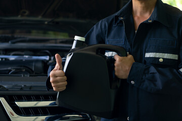 Mechanic's set. Holding a gallon of engine oil black color. Thumbs up showing great signs. ensure...