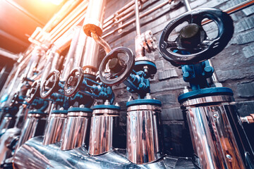 The valves and pipes at a craft modern brewery wall