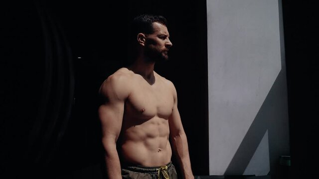 The profile of a bodybuilder, with a bare chest looking ahead. Intense masculine energy. Healthy lifestyle. Sport concept