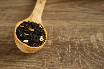 Tea with orange on a wooden spoon