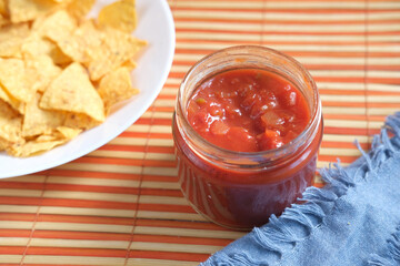 a bowl of chips and salsa on table ,