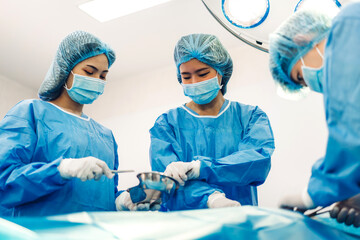 Professional anesthesiologist doctor medical team and assistant preparing patient to gynecological surgery performing operating with surgery equipment in modern hospital operation emergency room