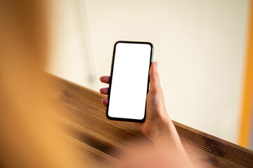 Woman using mobile phone with empty white screen, mockup for your app design.