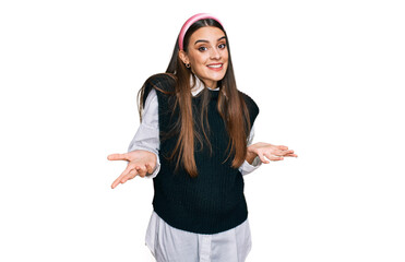 Young beautiful woman wearing casual white shirt clueless and confused expression with arms and...