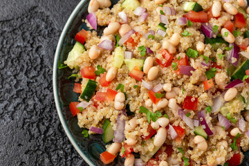 Quinoa white bean salad with cherry tomatoes, cucumber, red onion and herbs. Healthy vegan food