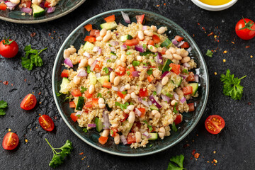 Quinoa white bean salad with cherry tomatoes, cucumber, red onion and herbs. Healthy vegan food