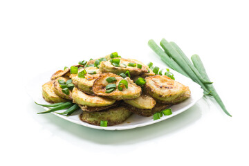 fried zucchini in circles with fresh herbs in a plate isolated on white