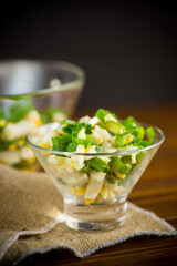 fresh spring salad with boiled squid, boiled eggs and green onions