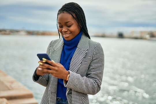 Young african american businesswoman smiling happy using smartphone at the port