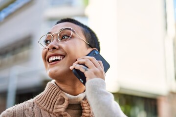 Young hispanic woman with short hair smiling happy speaking on the phone