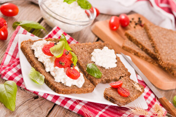 Rye bread with cottage cheese, basil and tomato.