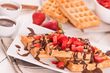Waffles with strawberries and chocolate cream.