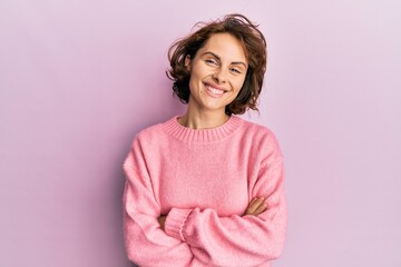 Young brunette woman wearing casual winter sweater happy face smiling with crossed arms looking at...
