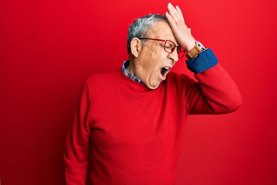 Handsome senior man with grey hair wearing casual clothes and glasses surprised with hand on head for mistake, remember error. forgot, bad memory concept.