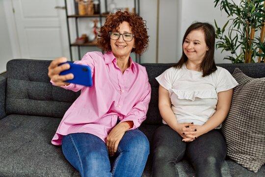 Mature mother and down syndrome daughter at home taking a selfie picture