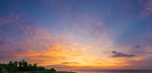 dramatic vibrant and saturated sky with beautiful clouds of sunset on the river bank