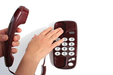 Female hands hold the telephone receiver and press the button