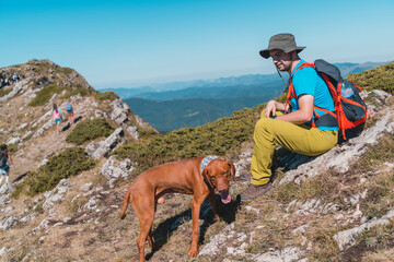 Young man hiking in he mountains with his dog