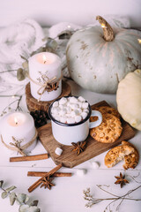 Autumn composition with cocoa with marshmallows, cookies, pumpkin and candles. 