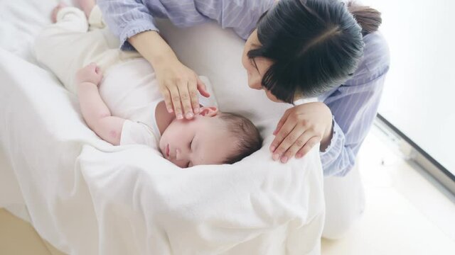 眠る赤ちゃんを見守る女性　スローモーション
