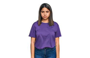 Young hispanic girl wearing casual purple t shirt skeptic and nervous, frowning upset because of...