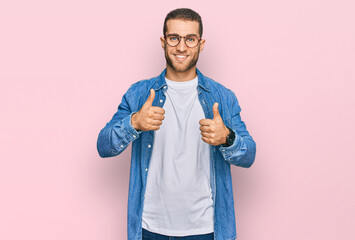 Young caucasian man wearing casual clothes success sign doing positive gesture with hand, thumbs up smiling and happy. cheerful expression and winner gesture.