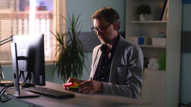 Mature office worker playing with fidget toy