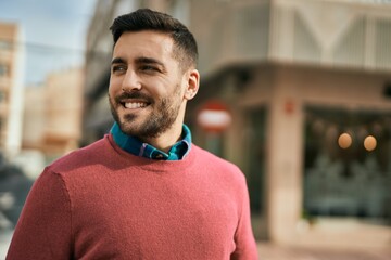 Fototapeta premium Young hispanic man smiling happy standing at the city.