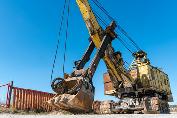 an old rusty quarry excavator is located on the territory of a mining quarry. an open method of mining.