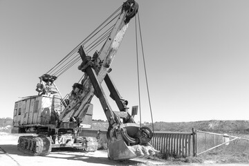 an old rusty quarry excavator is located on the territory of a mining quarry. an open method of mining.