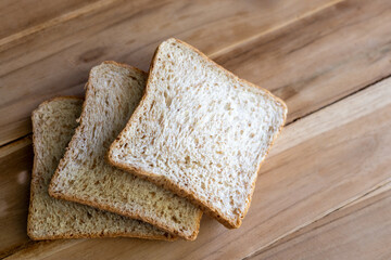 The three slices of bread were laid on a wooden table.