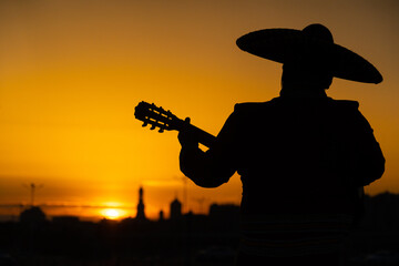 Mexican, Latin American, Spanish. Musician at sunset.