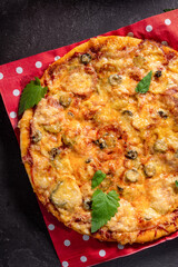 Pizza on a dark background. Order dinner online at a restaurant. Comfortable riding.