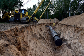 Natural Gas Pipeline Construction. Laying oil pipe in a trench in the ground. Petrochemical...