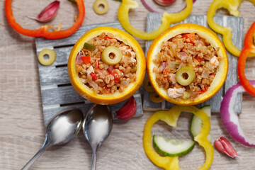 An exotic dish of bulgur, poultry and vegetables with oranges. Two portions of colorful stew, top view.