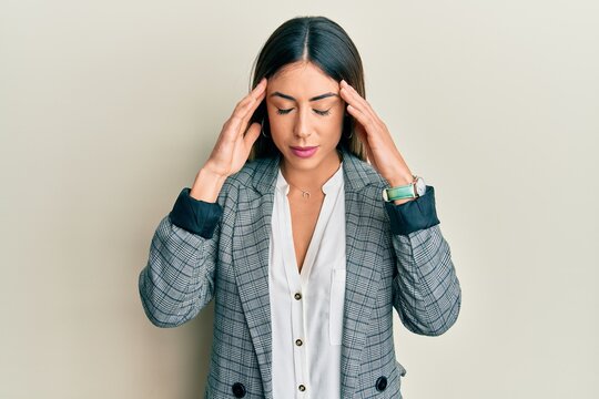 Young hispanic woman wearing business clothes with hand on head for pain in head because stress. suffering migraine.