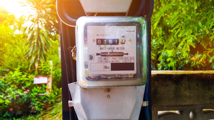 Watt-hour meter on the pole with the sunlight and blur background 