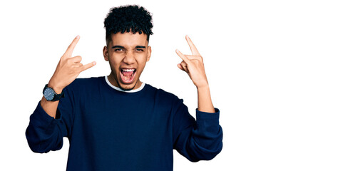 Young african american man wearing casual clothes shouting with crazy expression doing rock symbol...