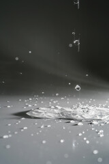 Obraz na płótnie Canvas Falling water drops on a shadow background.