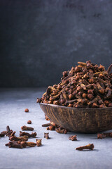 dried cloves in a cup made out of coconut shell, aromatic spice and herb, closeup side view