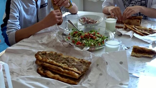 A family eating meat bread, Turkish style pide with meat,