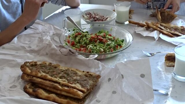 A family eating meat bread, Turkish style pide with meat,