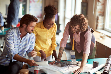 Group of young creative people in the office is looking project drafts